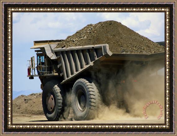 Raymond Gehman A Dump Truck Carrying Gravel Kicks Up a Cloud of Dust Framed Print