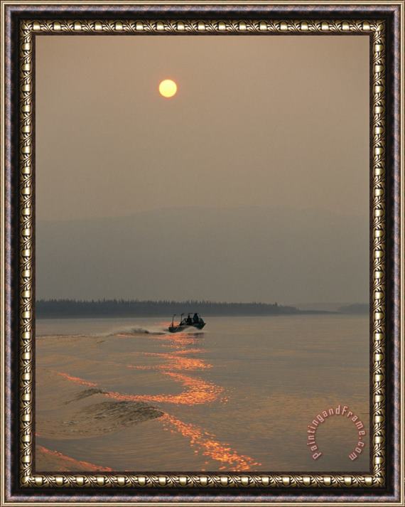 Raymond Gehman A Jet Boat Cruises Down The Mackenzie River at Sunset Framed Print