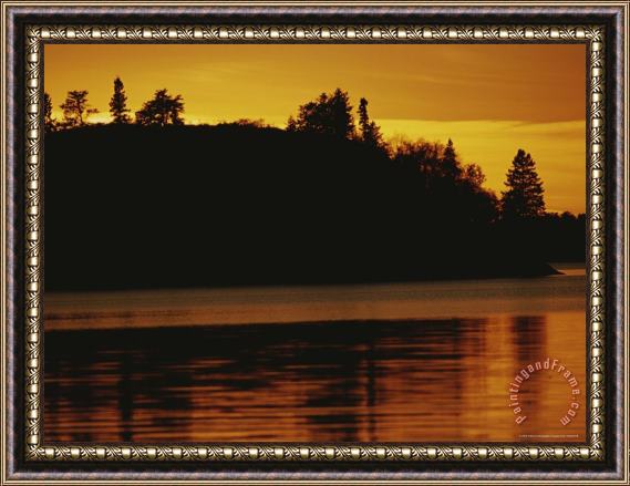 Raymond Gehman A Twilight View of a Lake And a Silhouette of a Tree Covered Mountain Framed Print