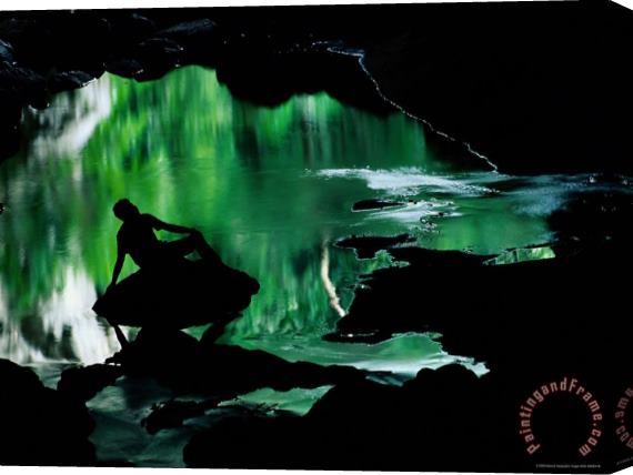 Raymond Gehman A Man Is Silhouetted Against an Emerald Green Pool of Water Stretched Canvas Print / Canvas Art
