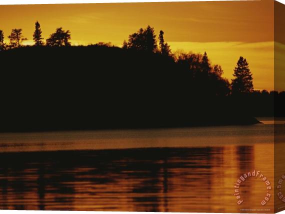 Raymond Gehman A Twilight View of a Lake And a Silhouette of a Tree Covered Mountain Stretched Canvas Print / Canvas Art
