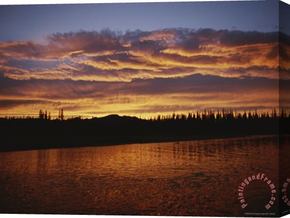 Raymond Gehman An Intense Sunset Colors Clouds And The Water of The Mackenzie River Stretched Canvas Painting / Canvas Art