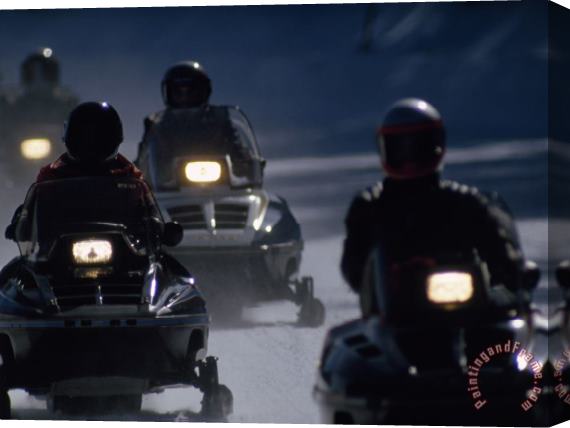 Raymond Gehman Snowmobilers Ride Down a Snowy Road in Yellowstone Park Stretched Canvas Print / Canvas Art
