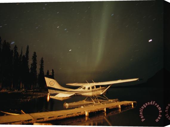 Raymond Gehman The Aurora Borealis Glows Brightly Over a Seaplane Docked on Cli Lake Stretched Canvas Print / Canvas Art